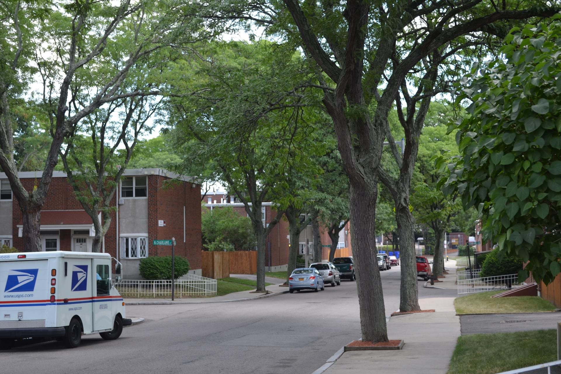 A USPS mail truck is parked on a residential street.